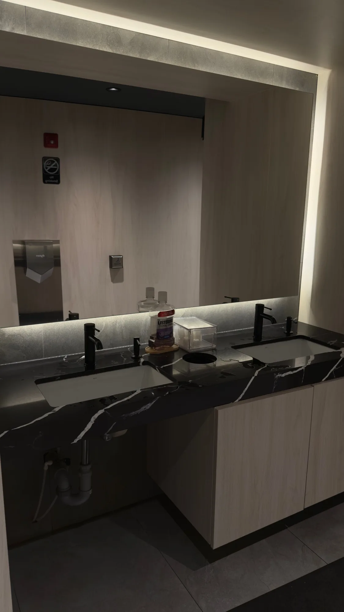 Commercial double vanity with black quartz countertop, undermount sinks, and backlit mirror — D&D Interior Services